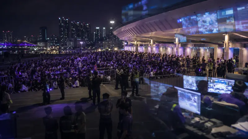 A purple-lit Busan stadium night with huge K-pop concert crowds moving through gates